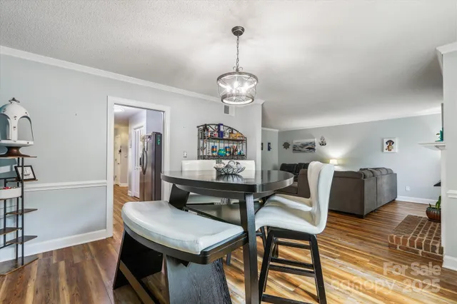 a view of a dining room with furniture a chandelier and wooden floor
