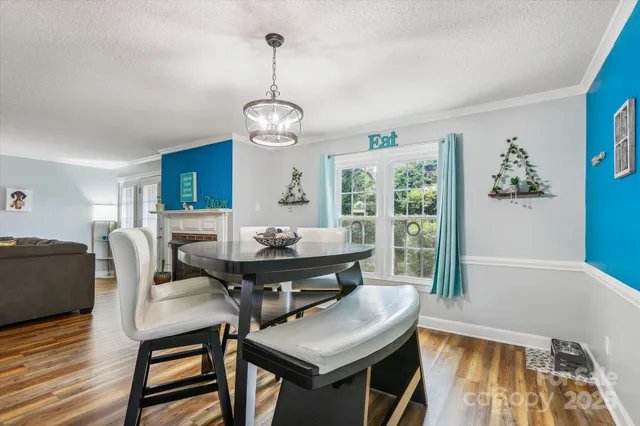a view of a dining room with furniture wooden floor and chandelier