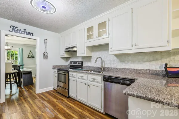 a kitchen with stainless steel appliances granite countertop a sink stove and cabinets