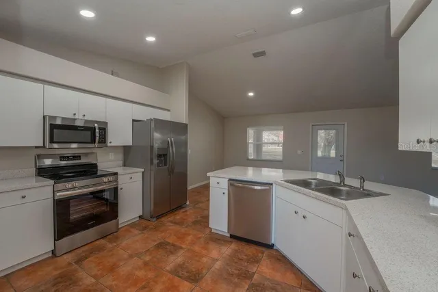 a kitchen with a sink stainless steel appliances and cabinets