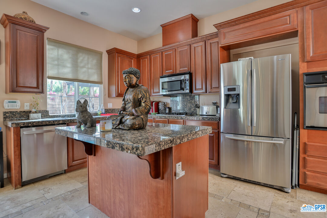 a kitchen with stainless steel appliances granite countertop a refrigerator stove and a sink