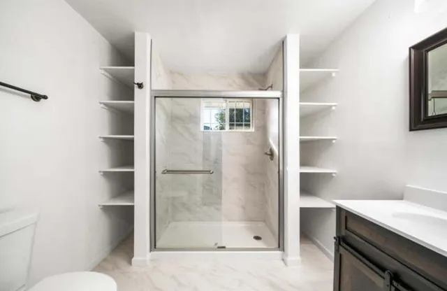 a bathroom with a shower toilet and sink