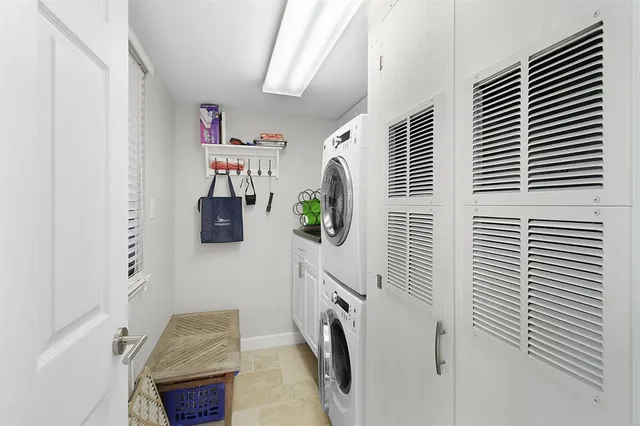 a swimming pool that has lawn chairs and a dining table under an ocean view
