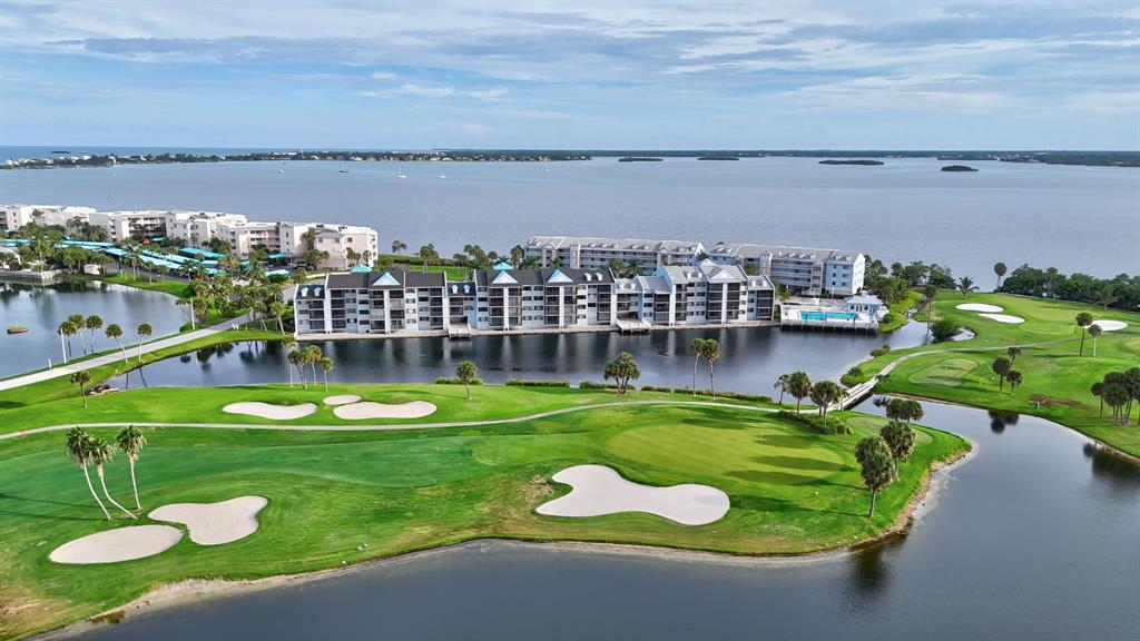 40 Northeast Plantation Road, Unit 109 Stuart, FL 34996 - Photo 32 of 41 a swimming pool that has lawn chairs and a dining table under an ocean view