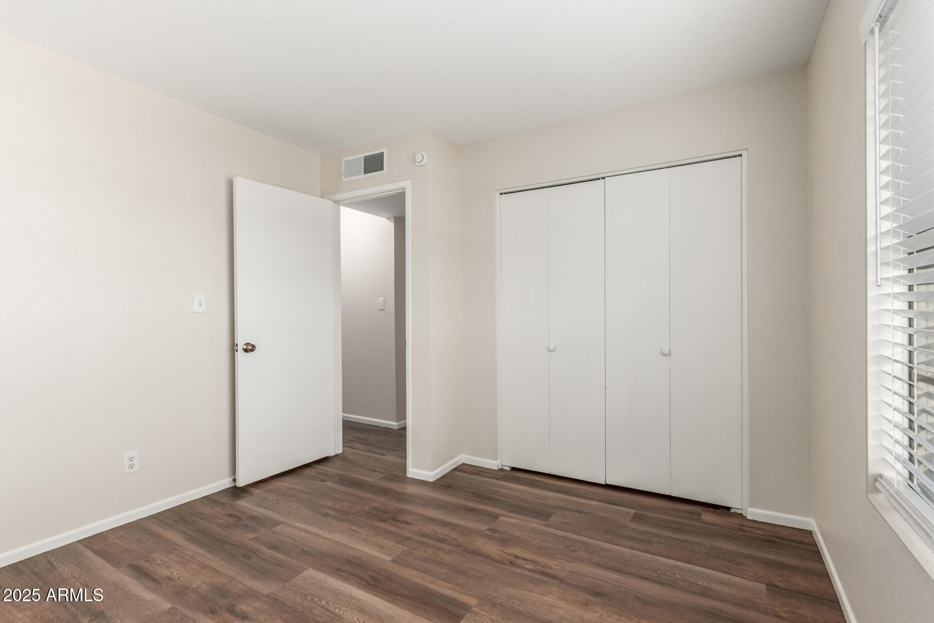 1126 West Elliot Road, Unit 1010 Chandler, AZ 85224 - Photo 14 of 32 a view of an empty room with wooden floor and a window