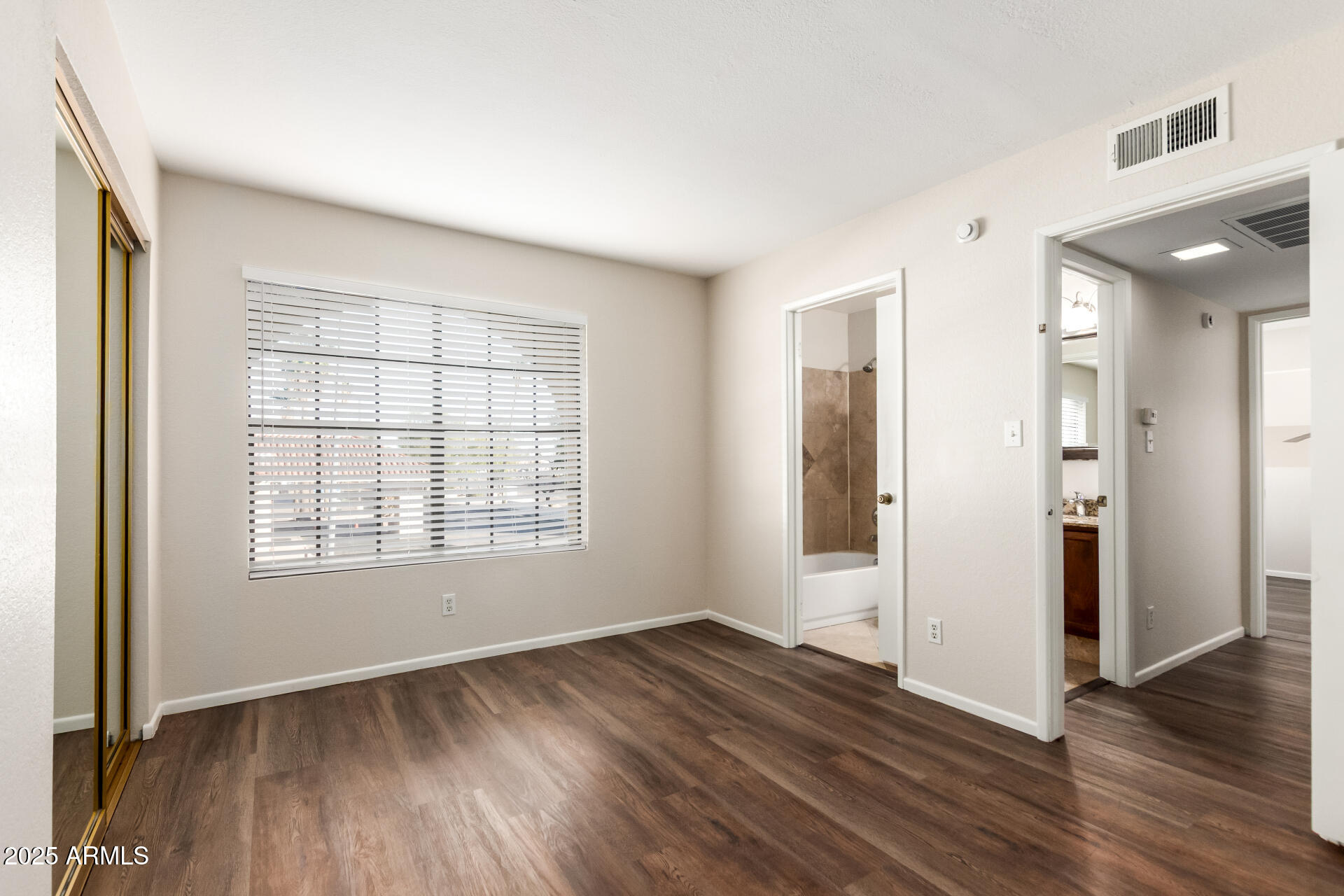 1126 West Elliot Road, Unit 1010 Chandler, AZ 85224 - Photo 16 of 32 an empty room with wooden floor and windows