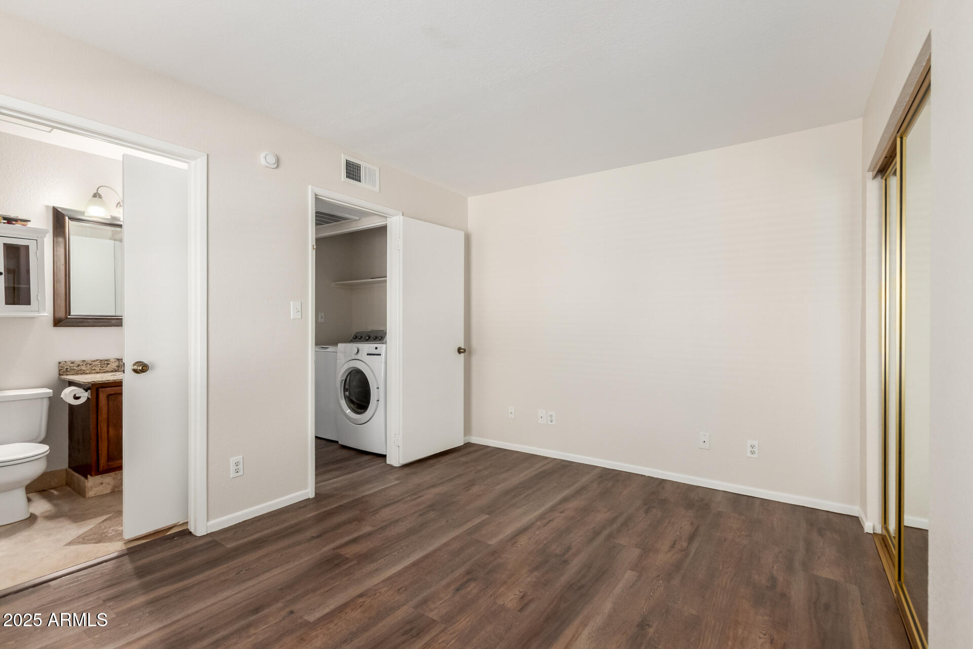 1126 West Elliot Road, Unit 1010 Chandler, AZ 85224 - Photo 17 of 32 a view of an empty room with wooden floor and a bathroom