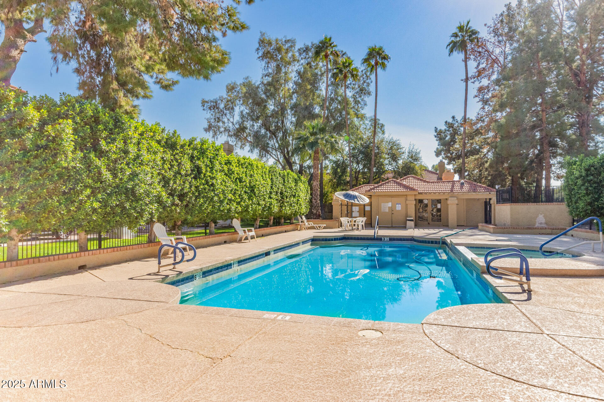 1126 West Elliot Road, Unit 1010 Chandler, AZ 85224 - Photo 27 of 32 a view of a swimming pool with lawn chairs under an umbrella