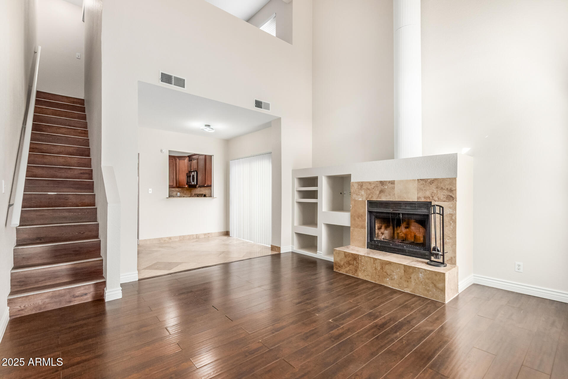 1126 West Elliot Road, Unit 1010 Chandler, AZ 85224 - Photo 3 of 32 a view of an empty room with wooden floor fire place