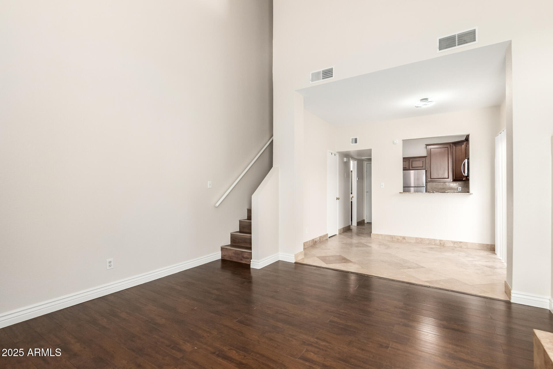 1126 West Elliot Road, Unit 1010 Chandler, AZ 85224 - Photo 5 of 32 a view of an empty room with wooden floor and a window
