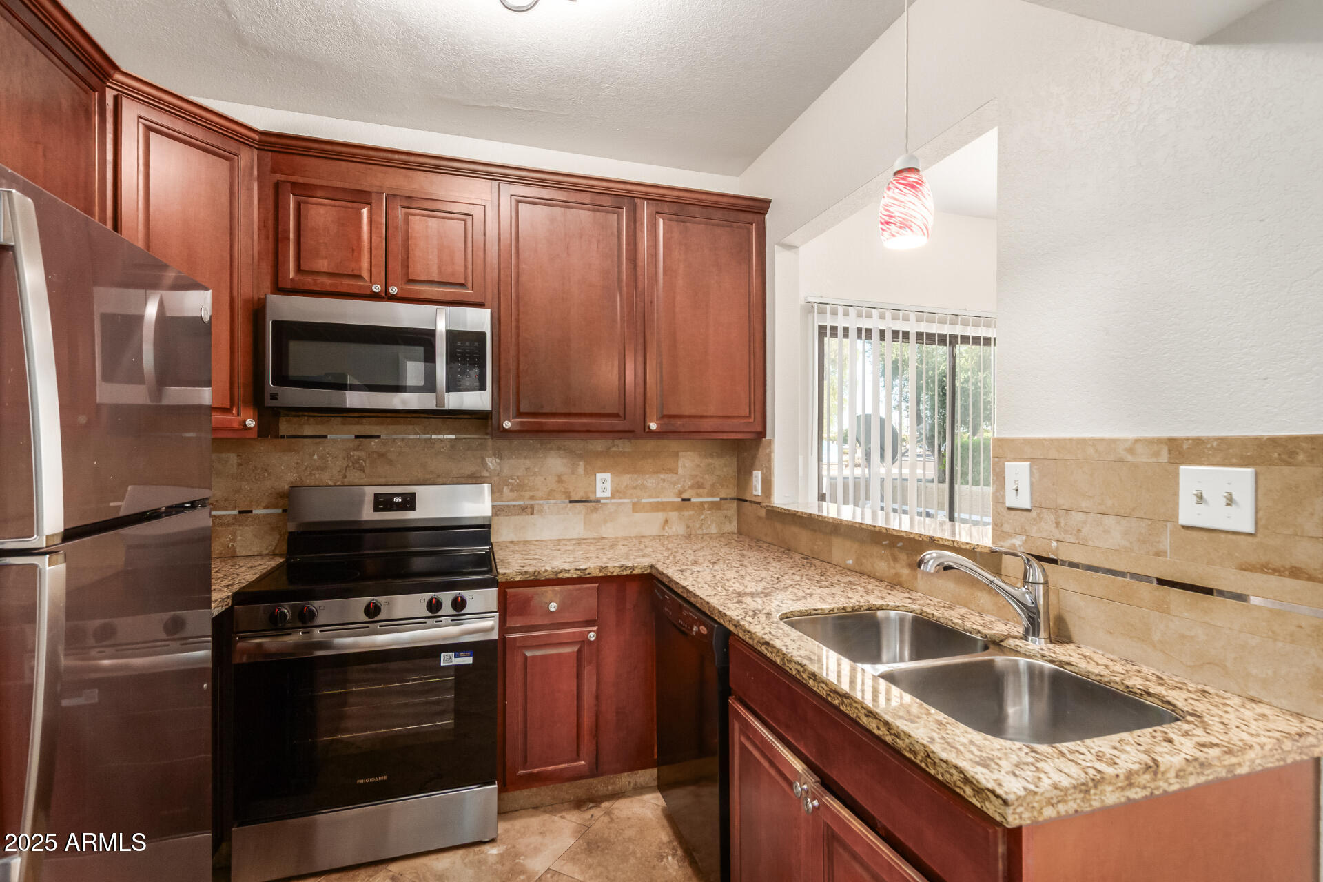 1126 West Elliot Road, Unit 1010 Chandler, AZ 85224 - Photo 9 of 32 a kitchen with granite countertop a sink stove and microwave