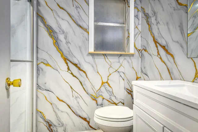 a bathroom with a toilet a sink and a window