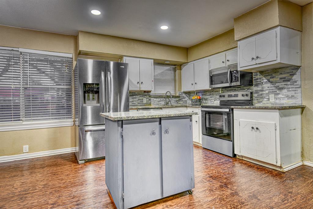 1304 Crestview Drive Kaufman, TX 75142 - Photo 7 of 26 a kitchen with stainless steel appliances granite countertop a stove a sink and a microwave