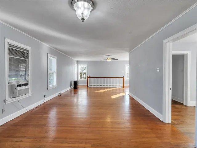 a view of empty room with wooden floor