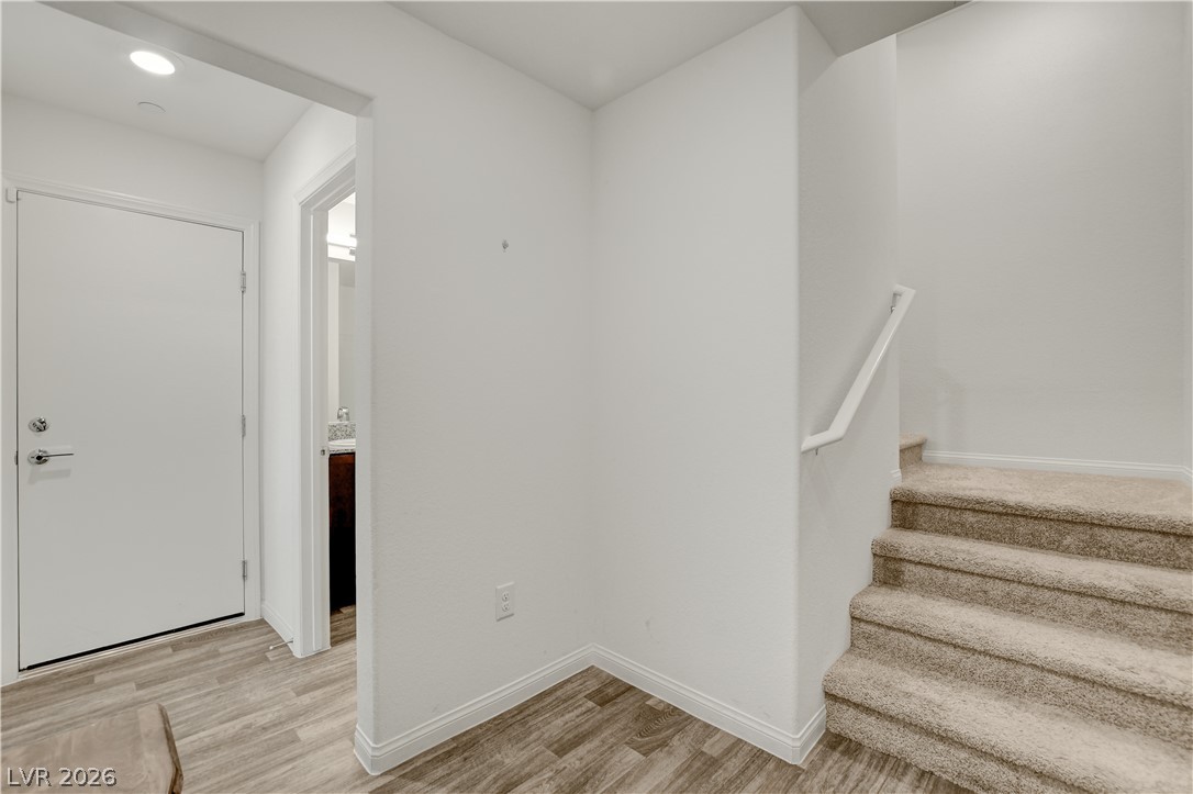 6924 Spicy Merlot Street North Las Vegas, NV 89086 - Photo 22 of 83 A welcoming entry hall with durable flooring leads to a powder room and carpeted stairs.