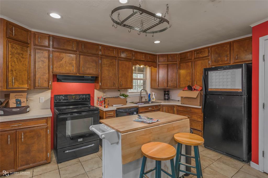 158 Edwards Road Doyline, LA 71023 - Photo 6 of 28 a kitchen with stainless steel appliances granite countertop a stove a refrigerator a sink a stove with island cabinets and wooden floor