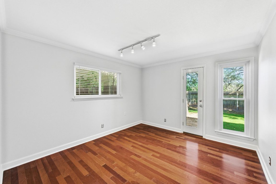 6210 Shadow Valley Drive, Unit B Austin, TX 78731 - Photo 20 of 28 Secondary room featuring crown molding, track lighting, wood finished floors, and plenty of natural light opening to front yard.
