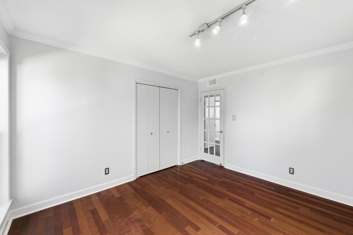 6210 Shadow Valley Drive, Unit B Austin, TX 78731 - Photo 21 of 28 Secondary bedroom featuring a closet, ornamental molding, dark wood-type flooring, and track lighting