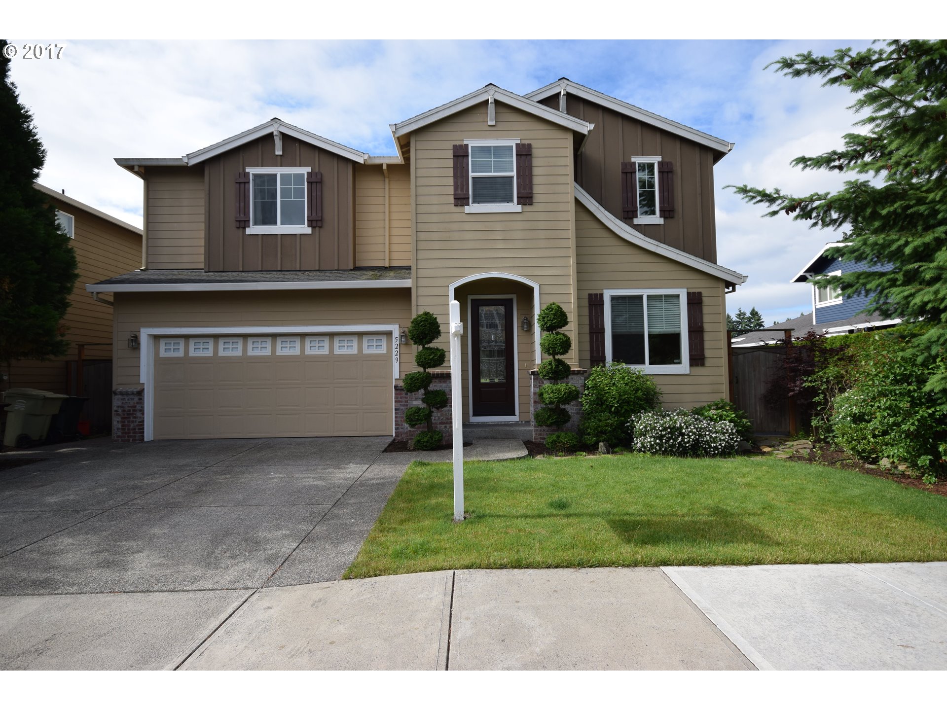 5229 Northwest Shoreline Way Portland, OR 97229 - Photo 1 of 29 a front view of a house with a yard and garage