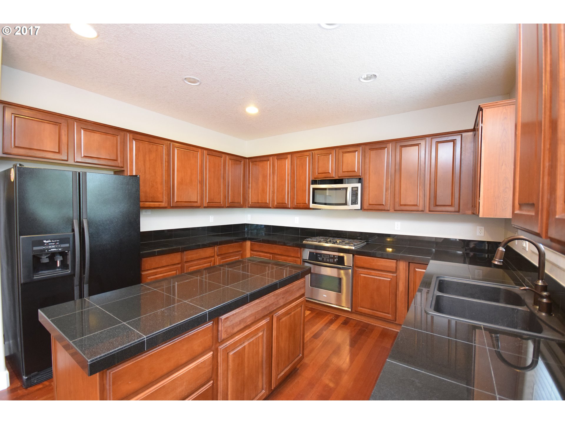 5229 Northwest Shoreline Way Portland, OR 97229 - Photo 12 of 29 a kitchen with stainless steel appliances granite countertop a sink stove and refrigerator
