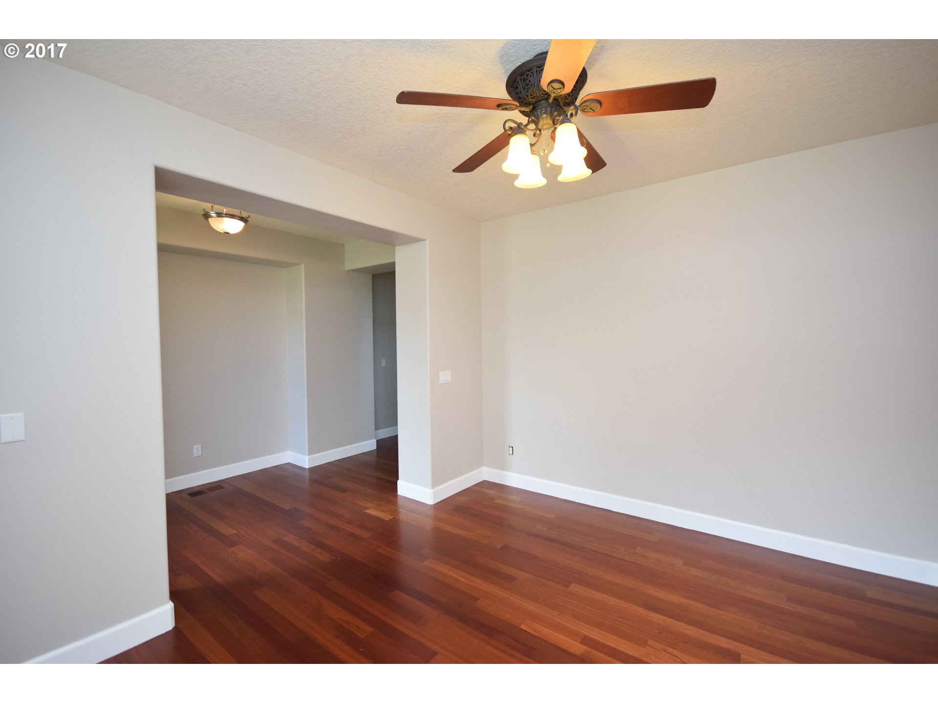 5229 Northwest Shoreline Way Portland, OR 97229 - Photo 3 of 29 an empty room with wooden floor chandelier fan