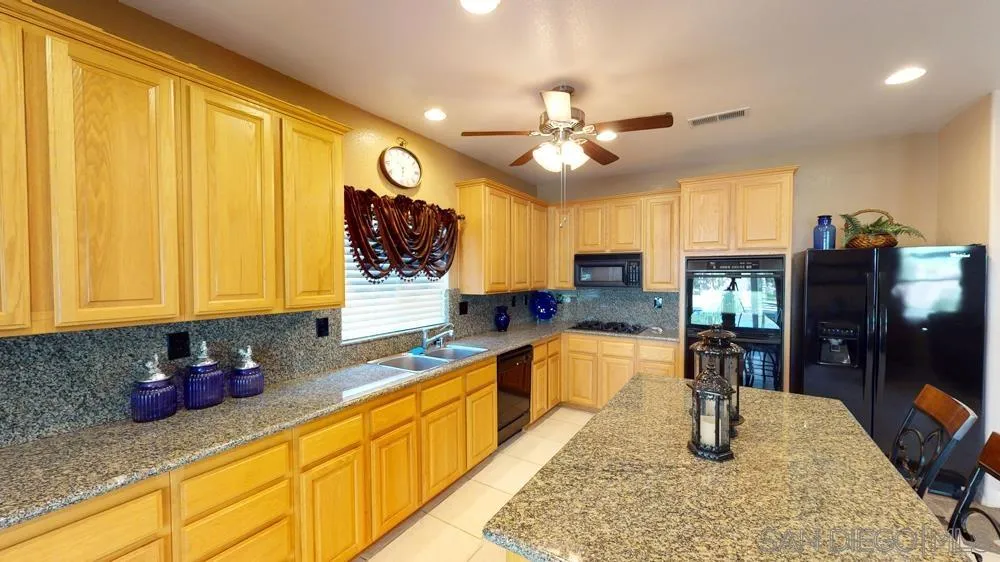 276 South Ralph Road Lake Elsinore, CA 92530 - Photo 4 of 15 a large kitchen with granite countertop lots of counter top space