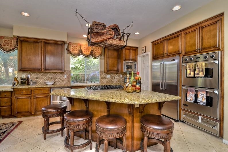 1206 Plum Tree Road Carlsbad, CA 92011 - Photo 14 of 25 GRANITE KITCHEN ISLAND WITH PLENTY OF ROOM FOR BAR STOOLS. SIX BURNER GAS COOKTOP