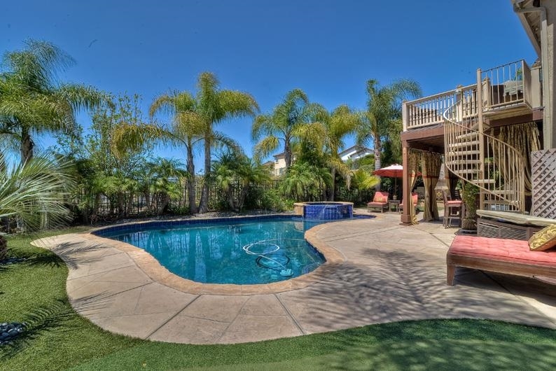 1206 Plum Tree Road Carlsbad, CA 92011 - Photo 5 of 25 BACKYARD INCLUDES CUSTOM POOL AND SPA, FIREPLACE, COVERED PATIO WITH DINING AND BAR AREA, BUILT-IN BBQ, DOG RUN, PLAY STRUCTURE, PLAY HOUSE OR ART STUDIO, AND SMALL PUTTING GREEN. BACKYARD BACKS TO OPEN SPACE, OCEAN VIEWS, AND WATCH FIREWORKS AT LEGOLAND
