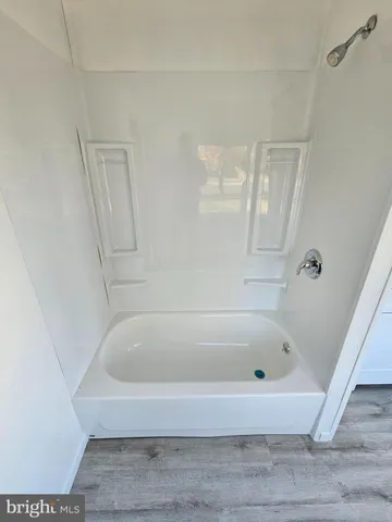 a white bath tub sitting next to a shower