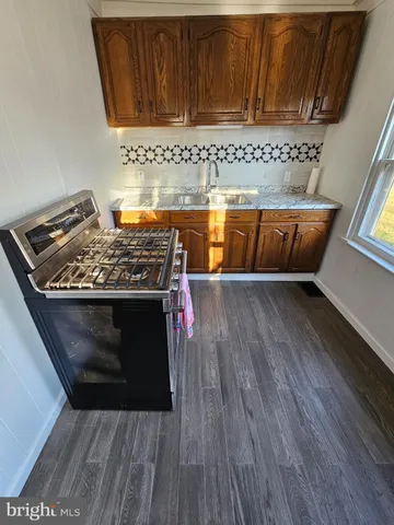 a view of a kitchen with wooden floor and cabinets