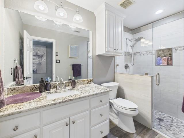 1101 Bunny Rabbit Road Athens, TX 75751 - Photo 31 of 40 a bathroom with a granite countertop sink a toilet and a mirror
