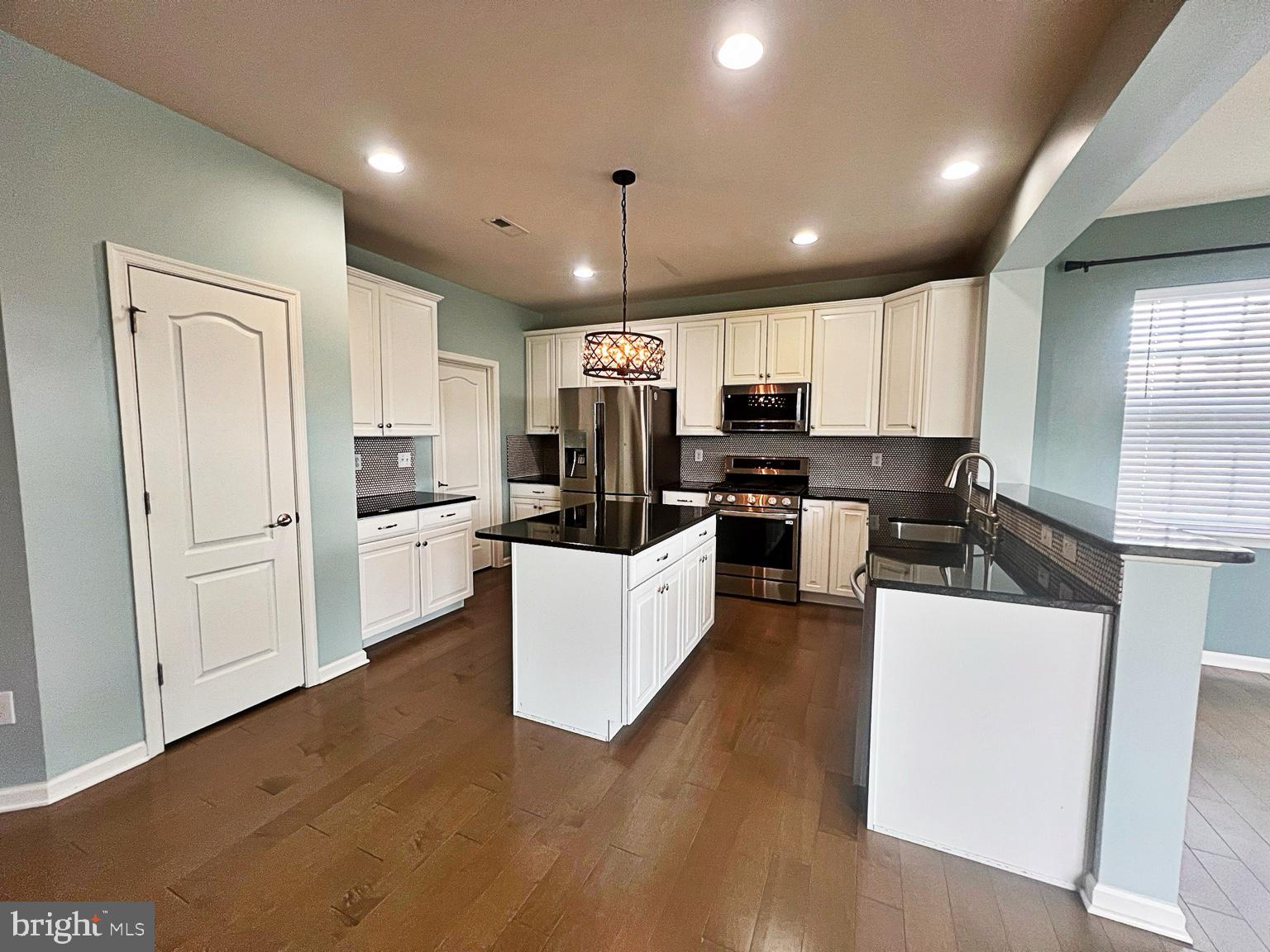 1147 Cardigan Road Middletown, DE 19709 - Photo 10 of 32 a kitchen with kitchen island a white counter top space stainless steel appliances and cabinets