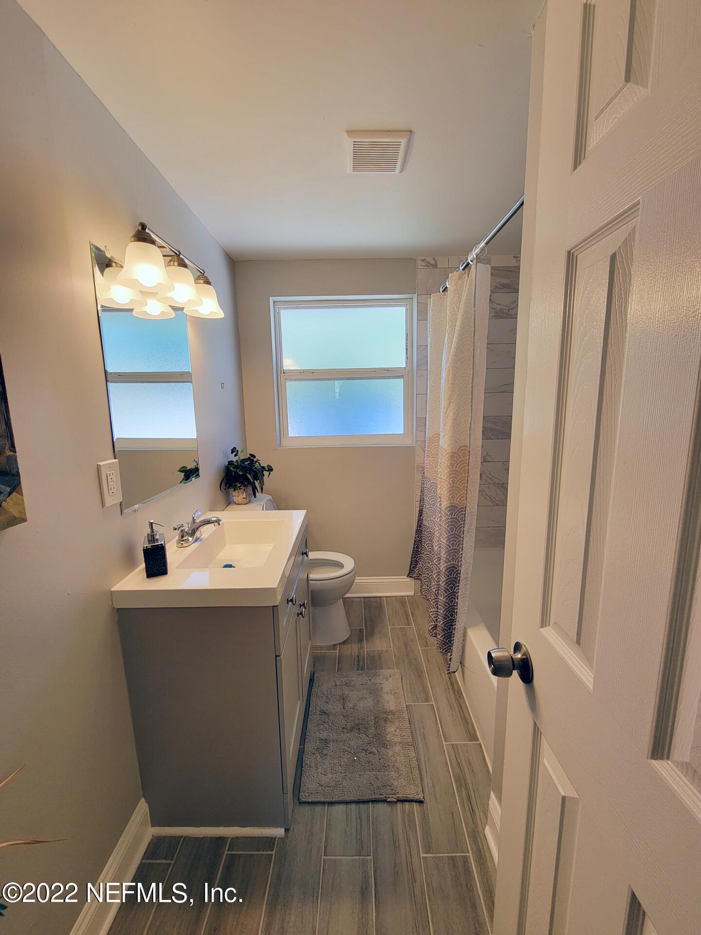 5118 Spring Glen Road Jacksonville, FL 32207 - Photo 20 of 33 a bathroom with a sink a toilet and a mirror