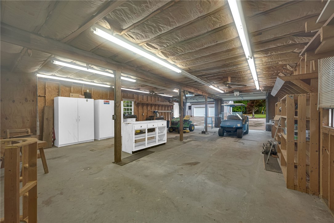 1016 Campbell Road Belton, SC 29627 - Photo 35 of 50 A spacious, well-lit workshop offers ample room for projects and storage, featuring durable concrete flooring.