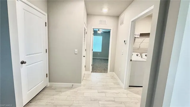 a view of a hallway with wooden floor and closet area