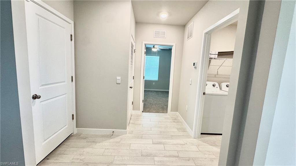 17710 Shade Tree Loop Babcock Ranch, FL 33982 - Photo 17 of 28 a view of a hallway with wooden floor and closet area