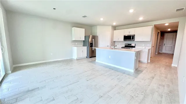 a large kitchen with stainless steel appliances a refrigerator and a stove top oven