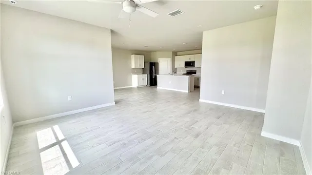 a view of a kitchen with wooden floor and electronic appliances