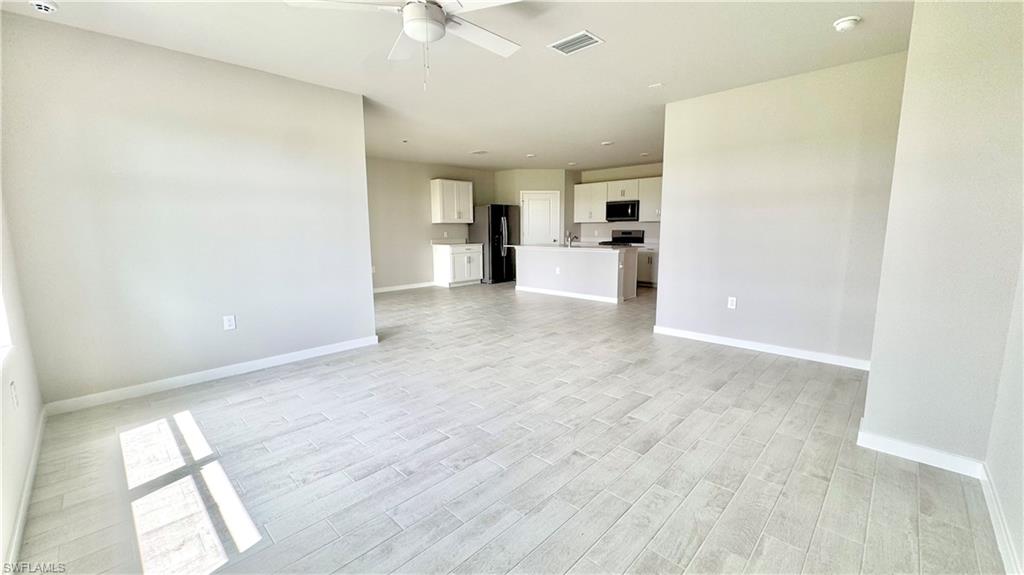 17710 Shade Tree Loop Babcock Ranch, FL 33982 - Photo 8 of 28 a view of a kitchen with wooden floor and electronic appliances