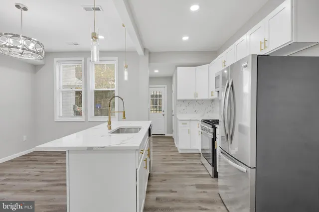 a kitchen with stainless steel appliances granite countertop a sink stove and refrigerator