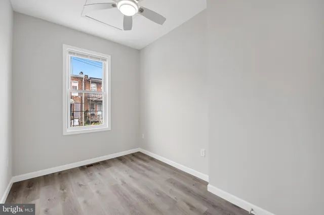an empty room with a window and a ceiling fan