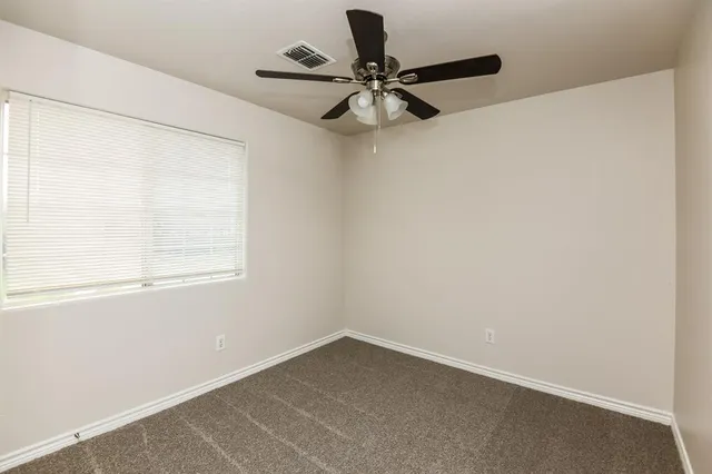 a view of a room with a window and a ceiling fan