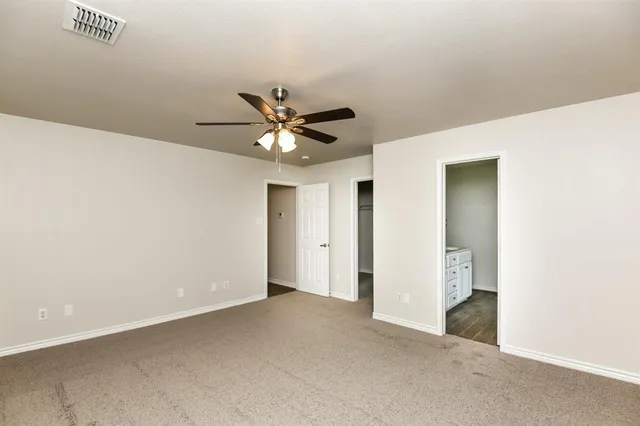 an empty room with a ceiling fan and a window