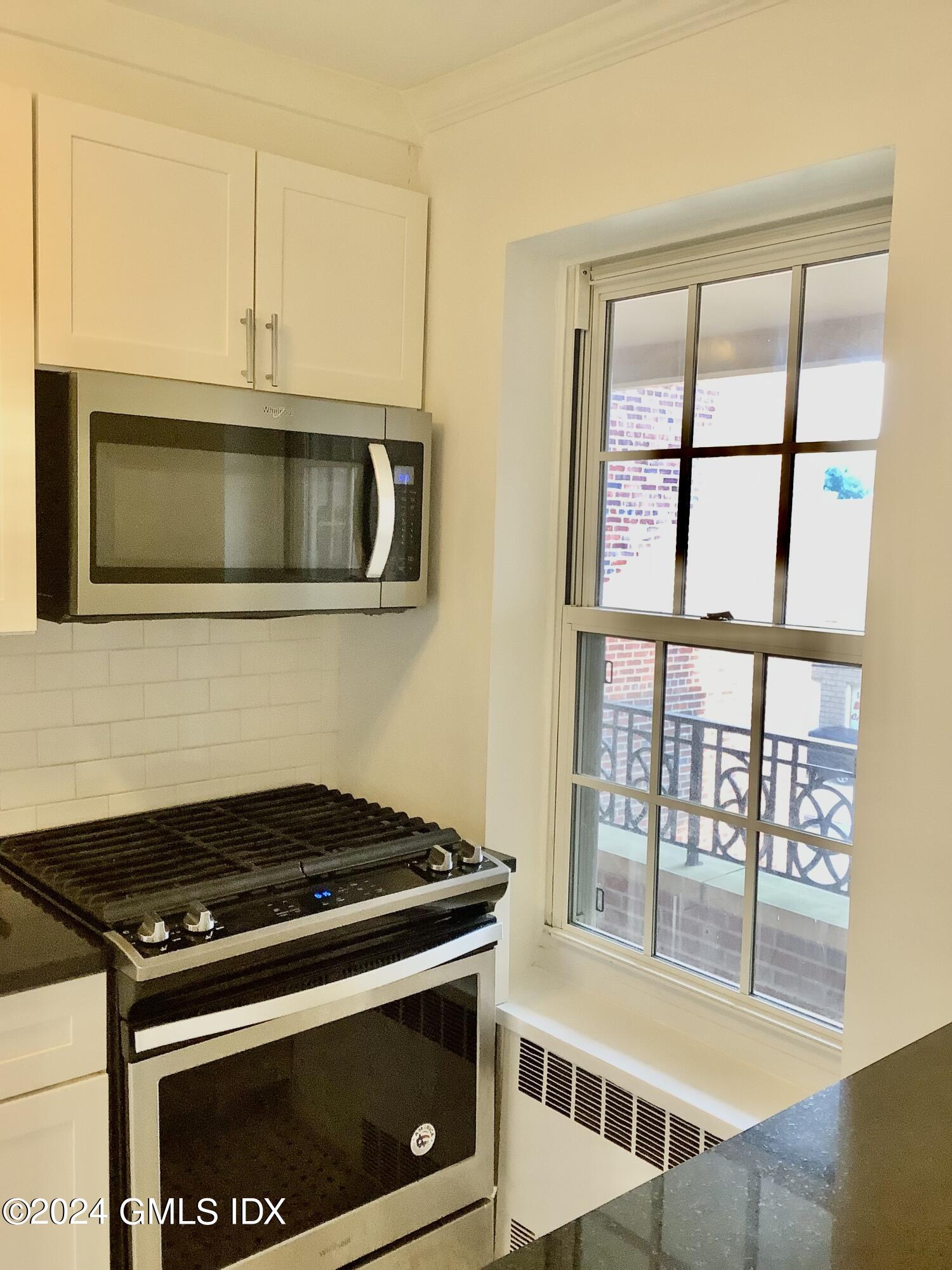 20 Church Street, Unit A26 Greenwich, CT 06830 - Photo 10 of 13 a kitchen with stainless steel appliances granite countertop a stove and a microwave