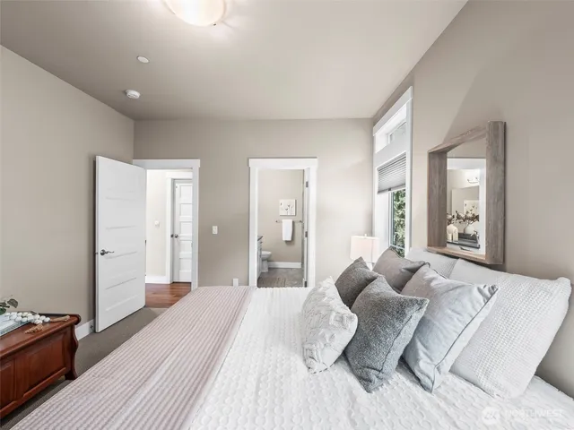 a bedroom with a bed and a large mirror