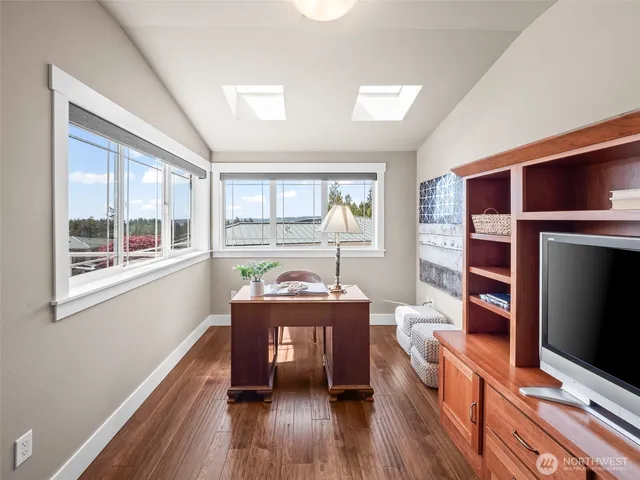 a reading room with wooden floor and furniture