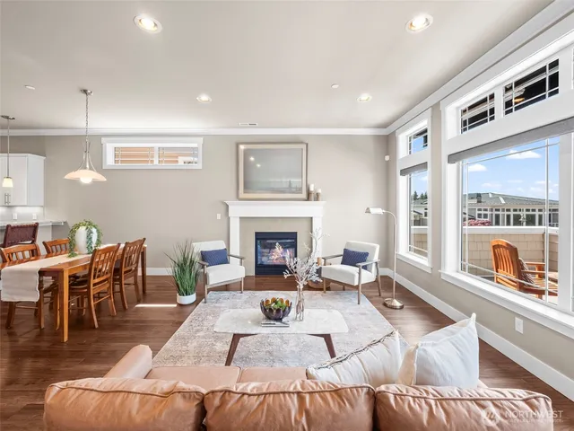 a living room with furniture two large windows and a fireplace