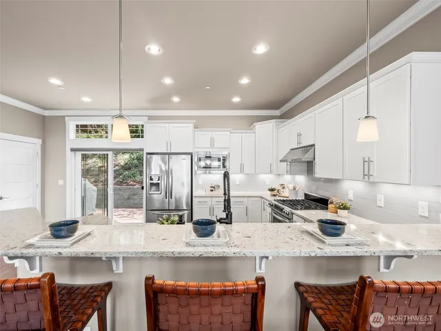 a kitchen with stainless steel appliances granite countertop a sink and a refrigerator