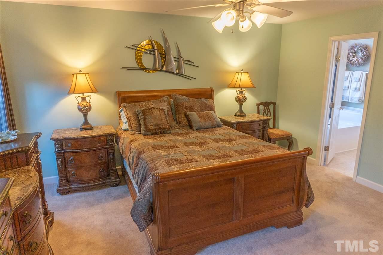 106 Braid Court Raleigh, NC 27603 - Photo 18 of 30 a bedroom with a bed and a chandelier