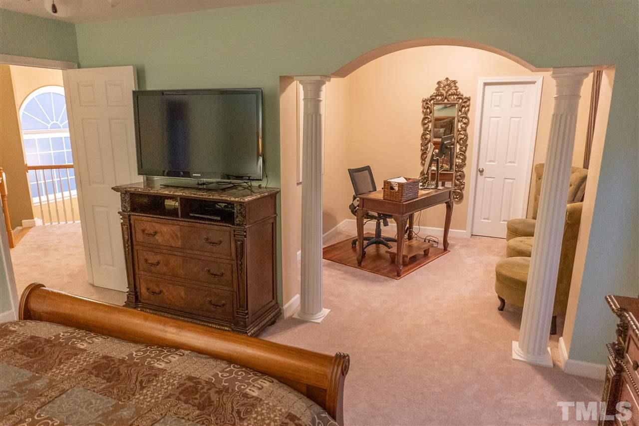 106 Braid Court Raleigh, NC 27603 - Photo 19 of 30 a living room with furniture a flat screen tv and a refrigerator